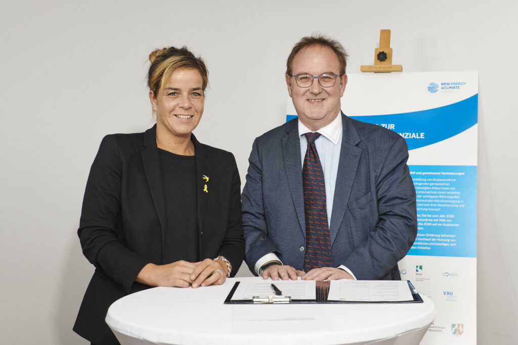 Mona Neubaur, Wirtschafts- und Klimaschutzministerin des Landes NRW und Dr. Peter Queitsch, Geschäftsführer der Kommunal Agentur NRW, bei der Unterzeichnung der neuen Initiative Abwasserwärme. Foto: ©NRW.Energy4Climate